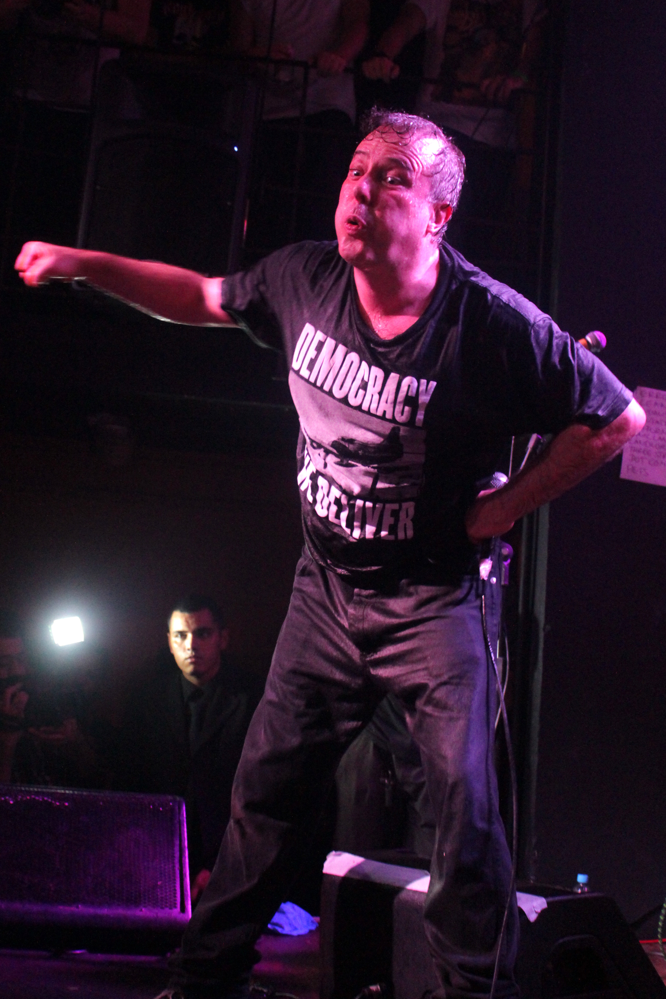 a man is standing on stage and holding out his arms