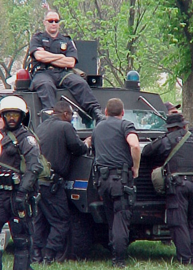 a group of men in uniform are sitting on top of an armored vehicle