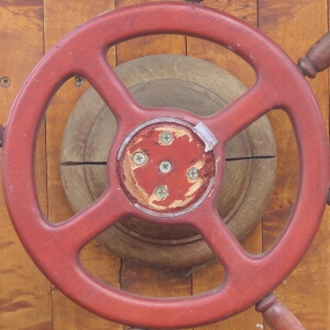 steering wheel attached to post next to wooden board