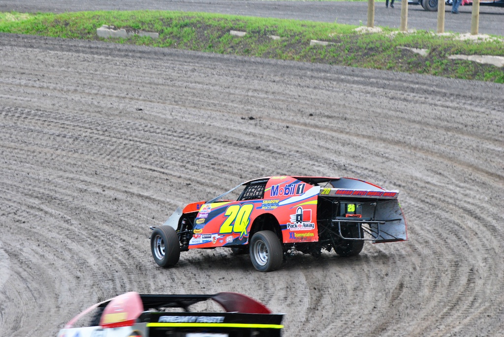a truck and a car are racing on the dirt