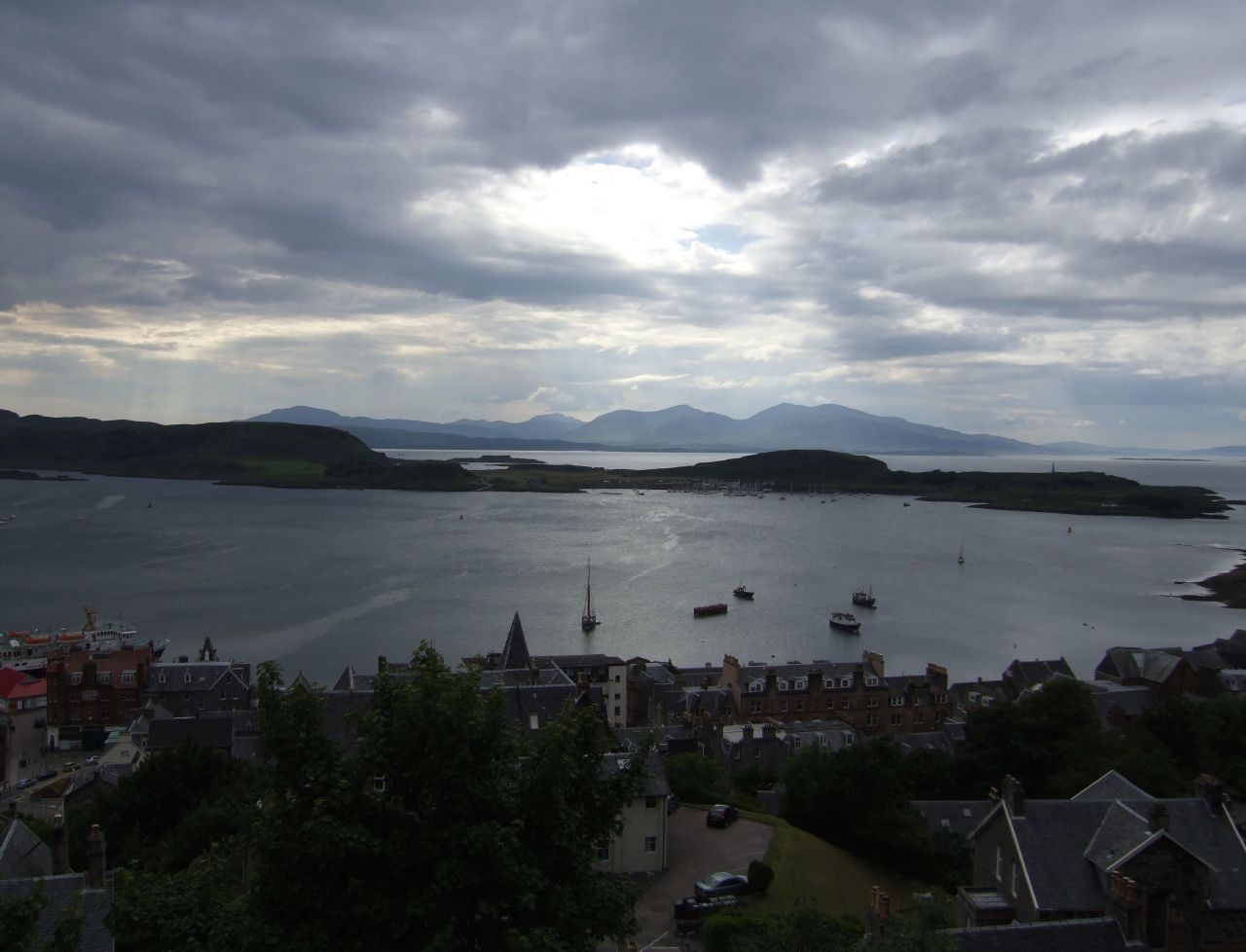 the sky has clouds over a bay and houses