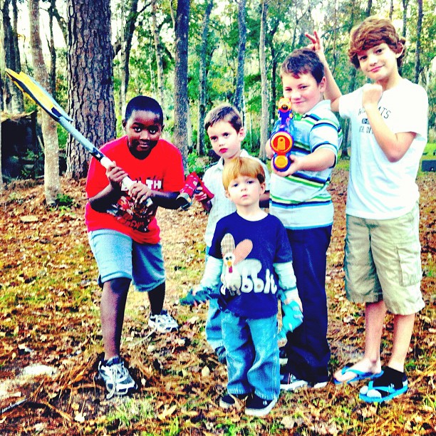 a group of children stand together and pose with bat