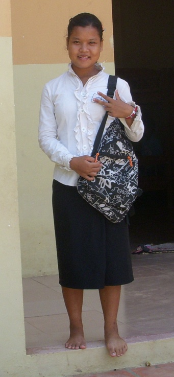 woman standing holding a purse while smiling
