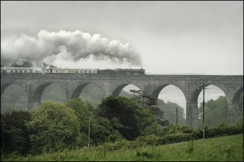 there is a train going over an old bridge