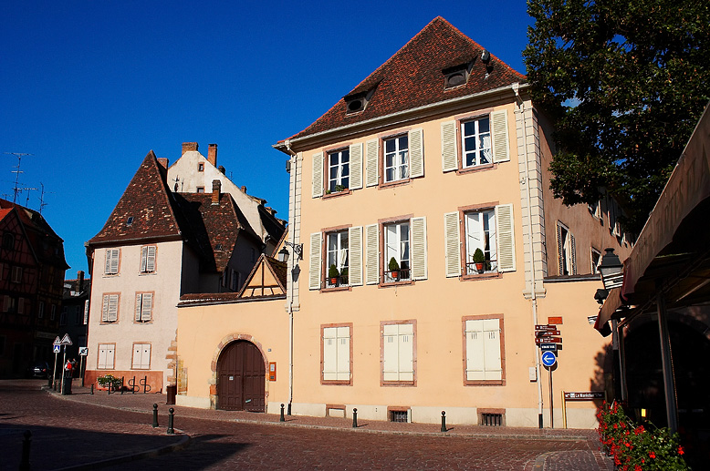 a building with many windows next to a cobblestone road