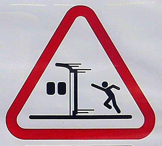 a pedestrian sign with a man standing on a lift