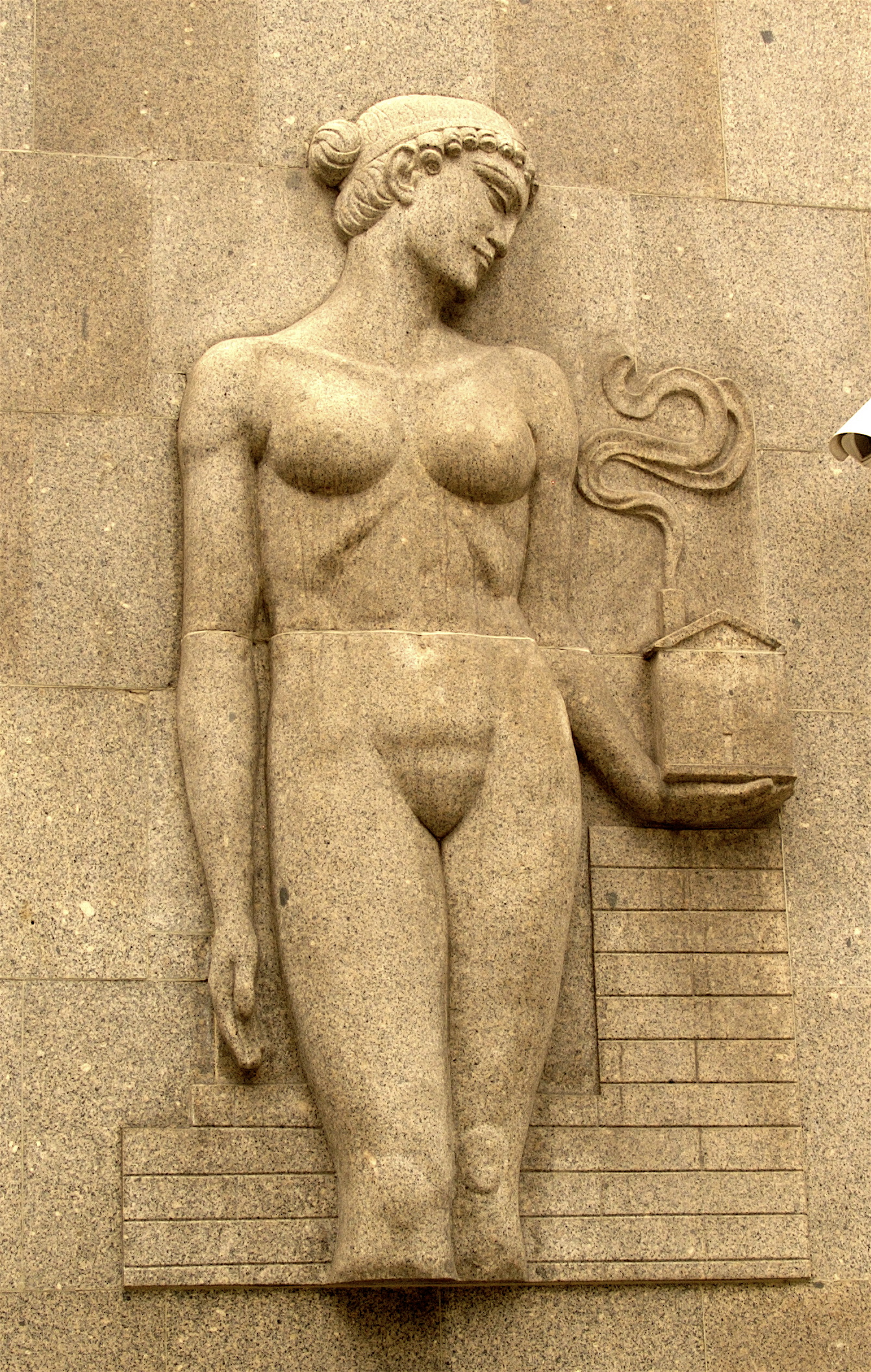 a statue on a wall with the symbol