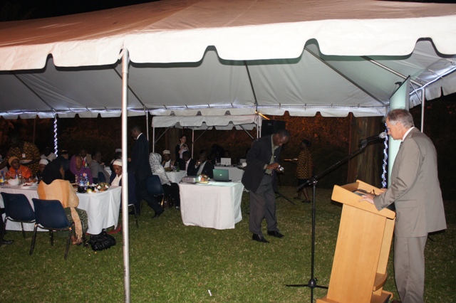 a man standing at a podium talking to people