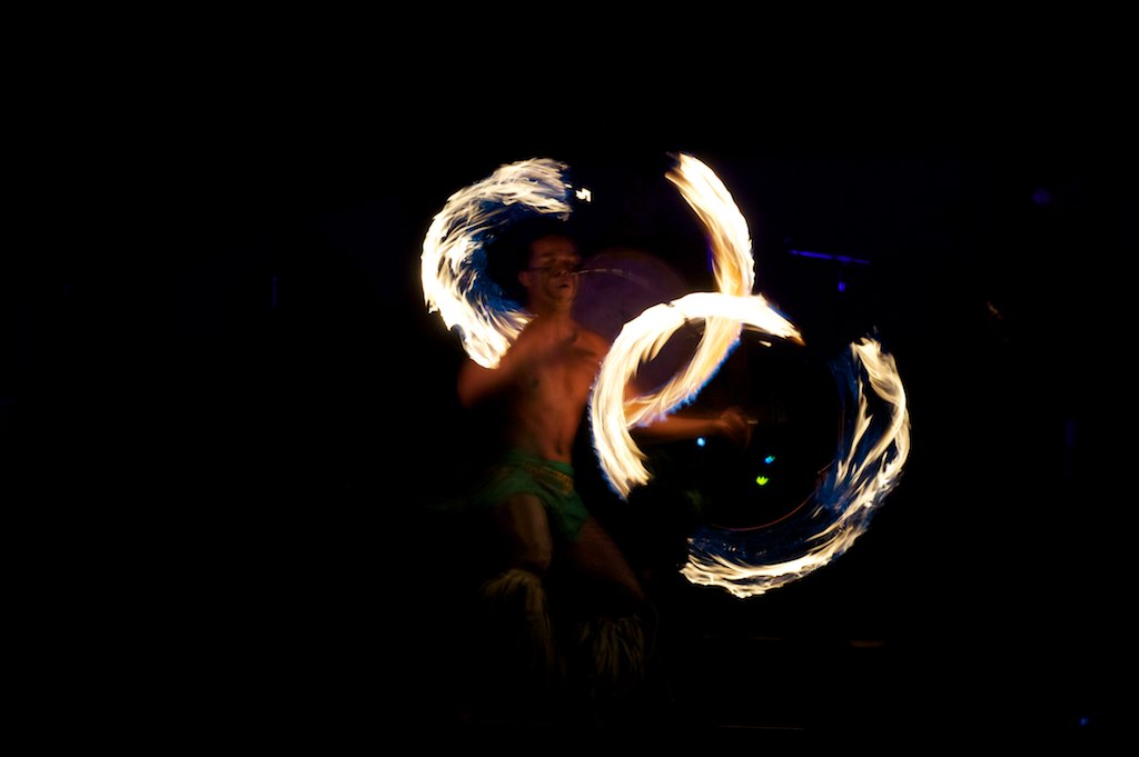 a man in a swimming suit is juggling with fire