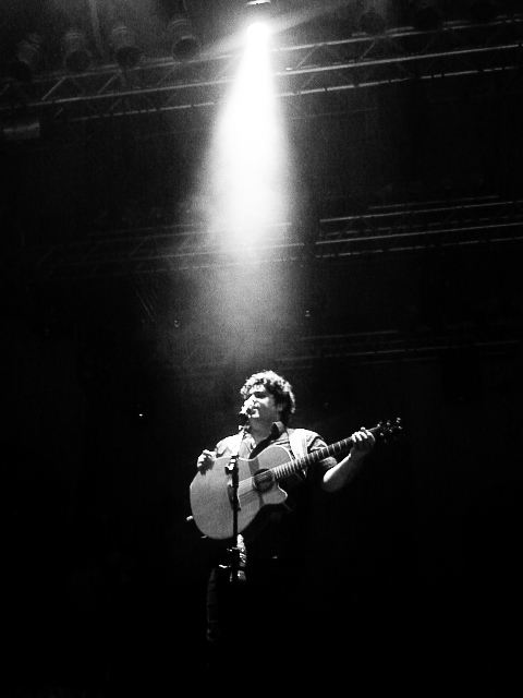 a man playing a guitar on a stage