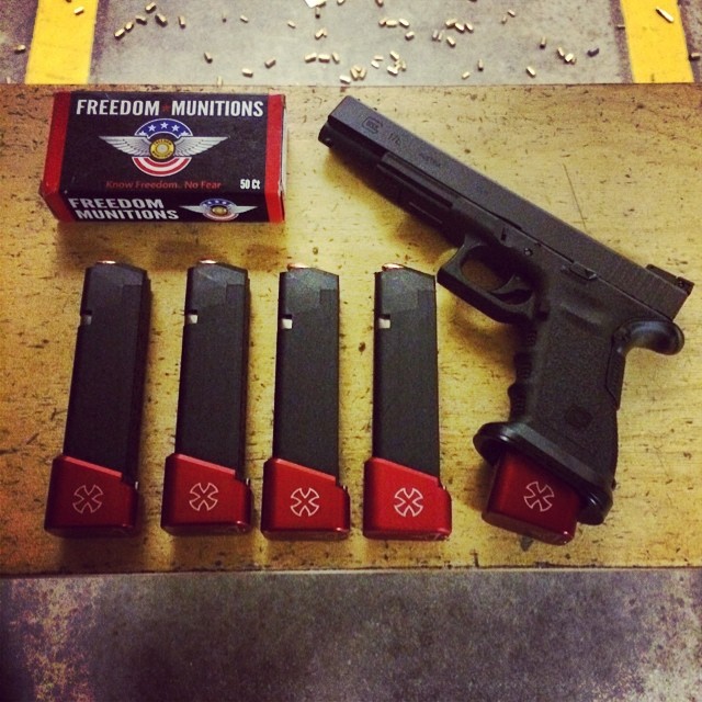 gun with eight magazines and four handguns on table