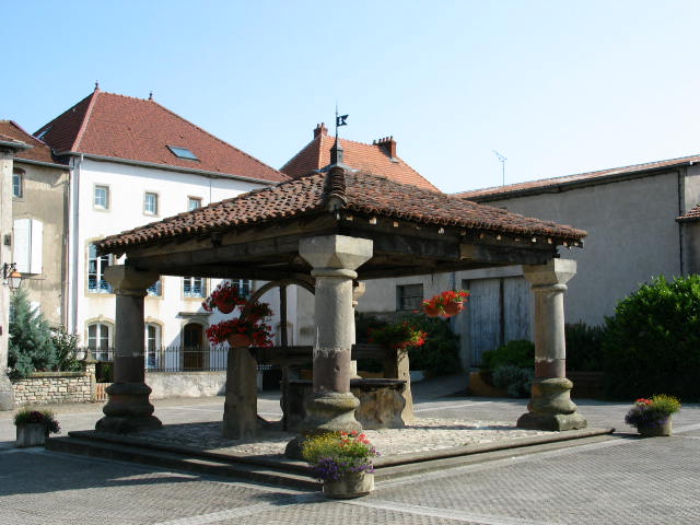 an old wooden gazebo surrounded by tall brick buildings