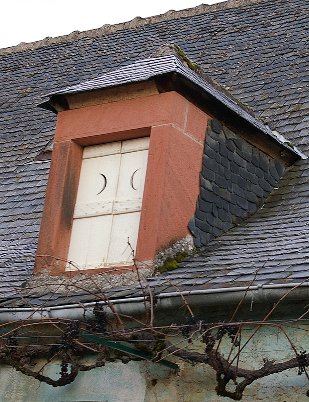 an old building has a window above the door