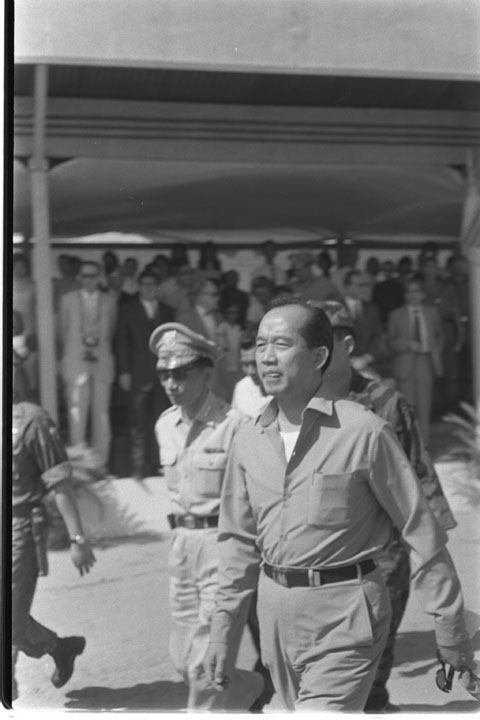 a black and white po of two men standing in front of a crowd of men