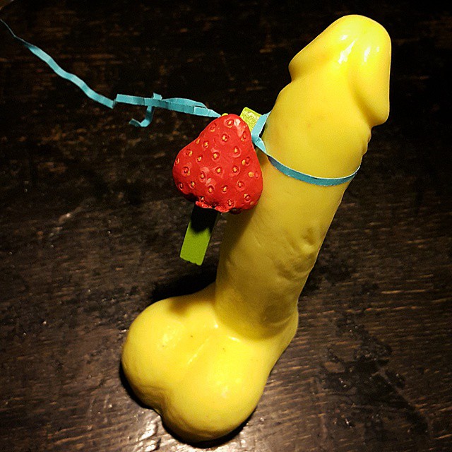 a yellow toy with a strawberries on its ear