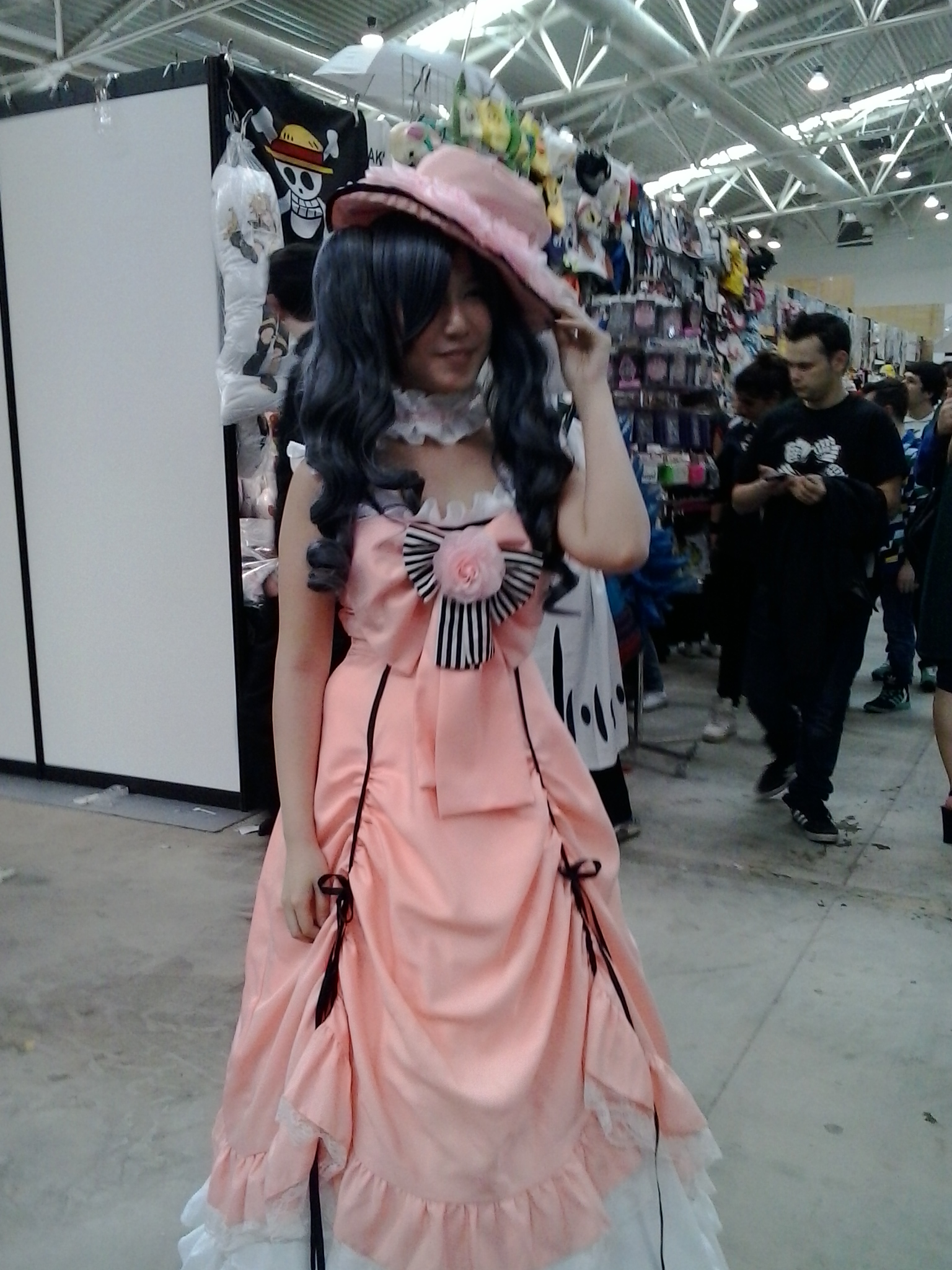 a girl in a pink dress stands in a market