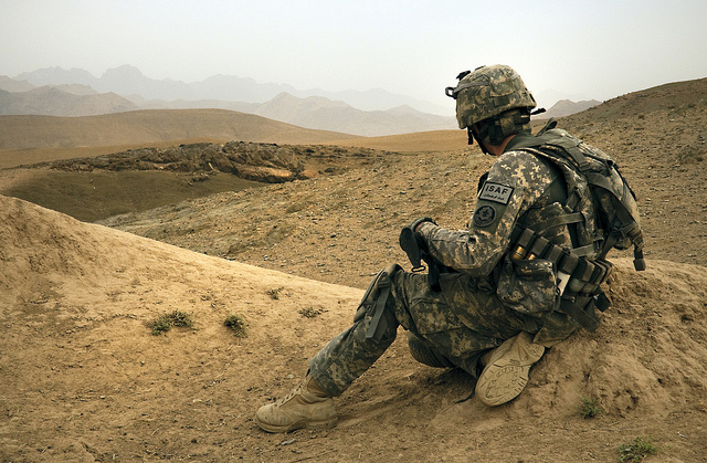 a soldier that is sitting on a mountain