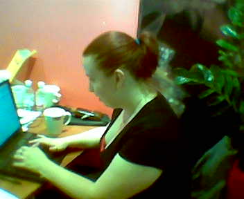 two women with computers at a desk in an office