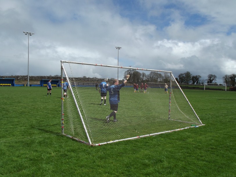 people playing soccer on a soccer field on a cloudy day