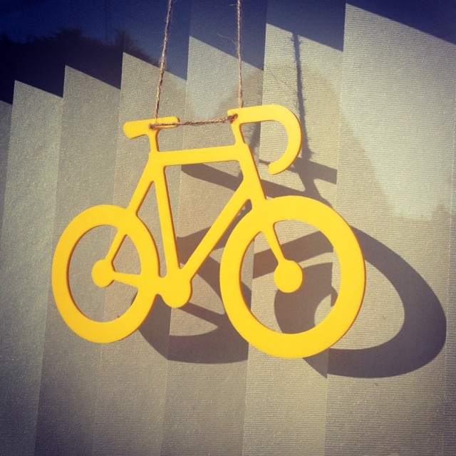 a wooden hanging sign with the shape of a bicycle