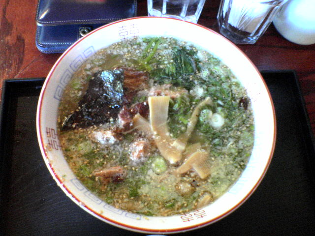 a bowl of broth with carrots and other foods