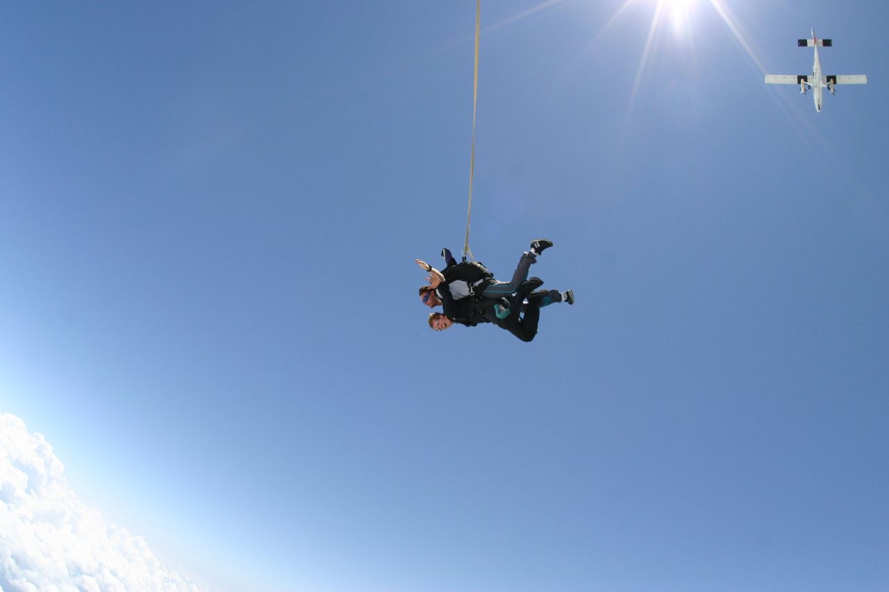 a man is flying through the air while holding onto a rope