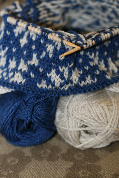 a blue and white basket and balls of yarn