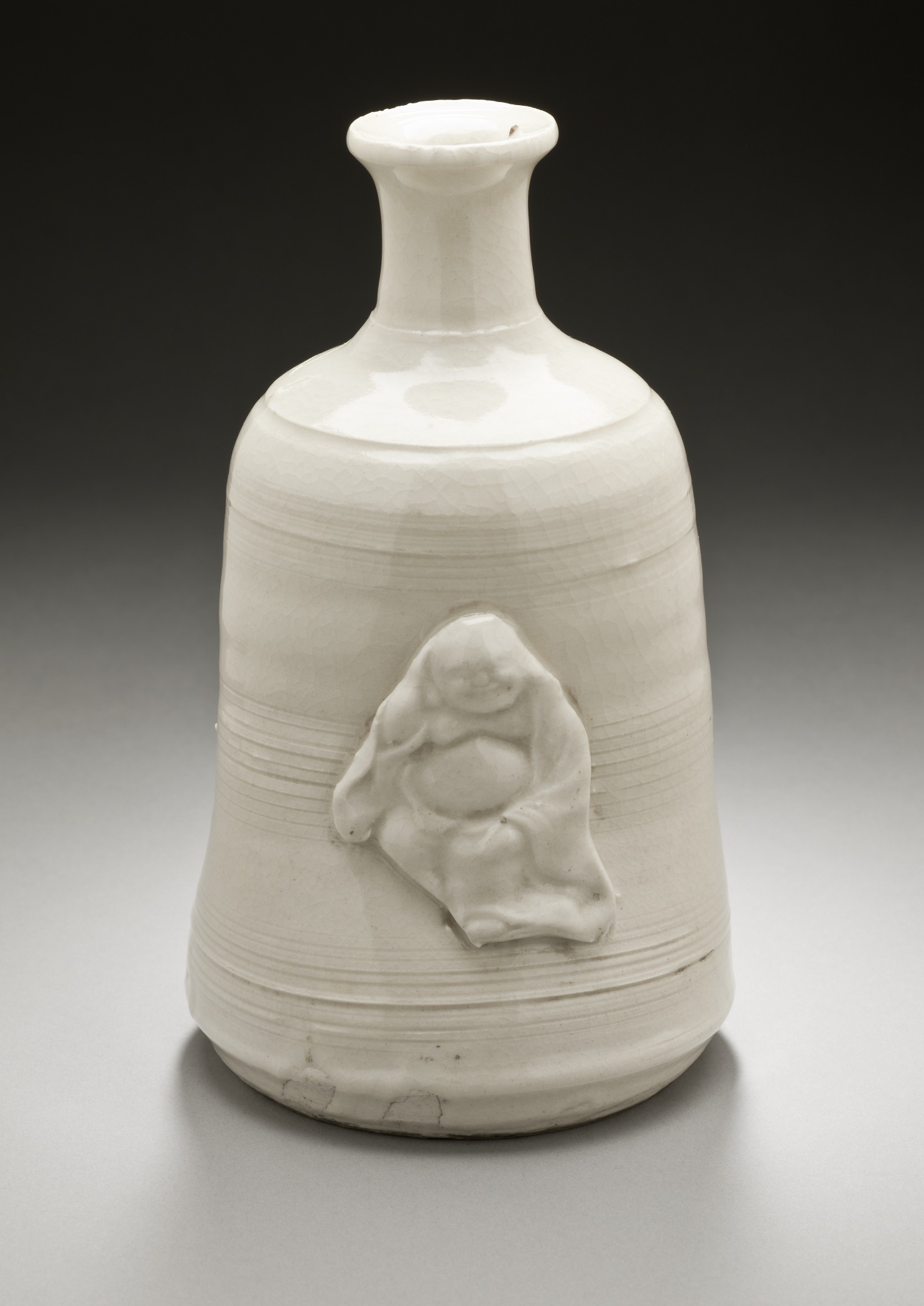 a white ceramic vase with a statue on the front