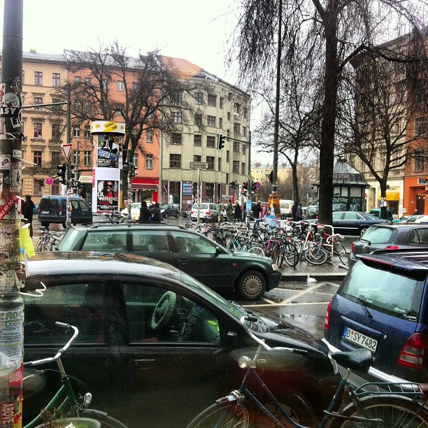 a city street filled with traffic and parked bicycles