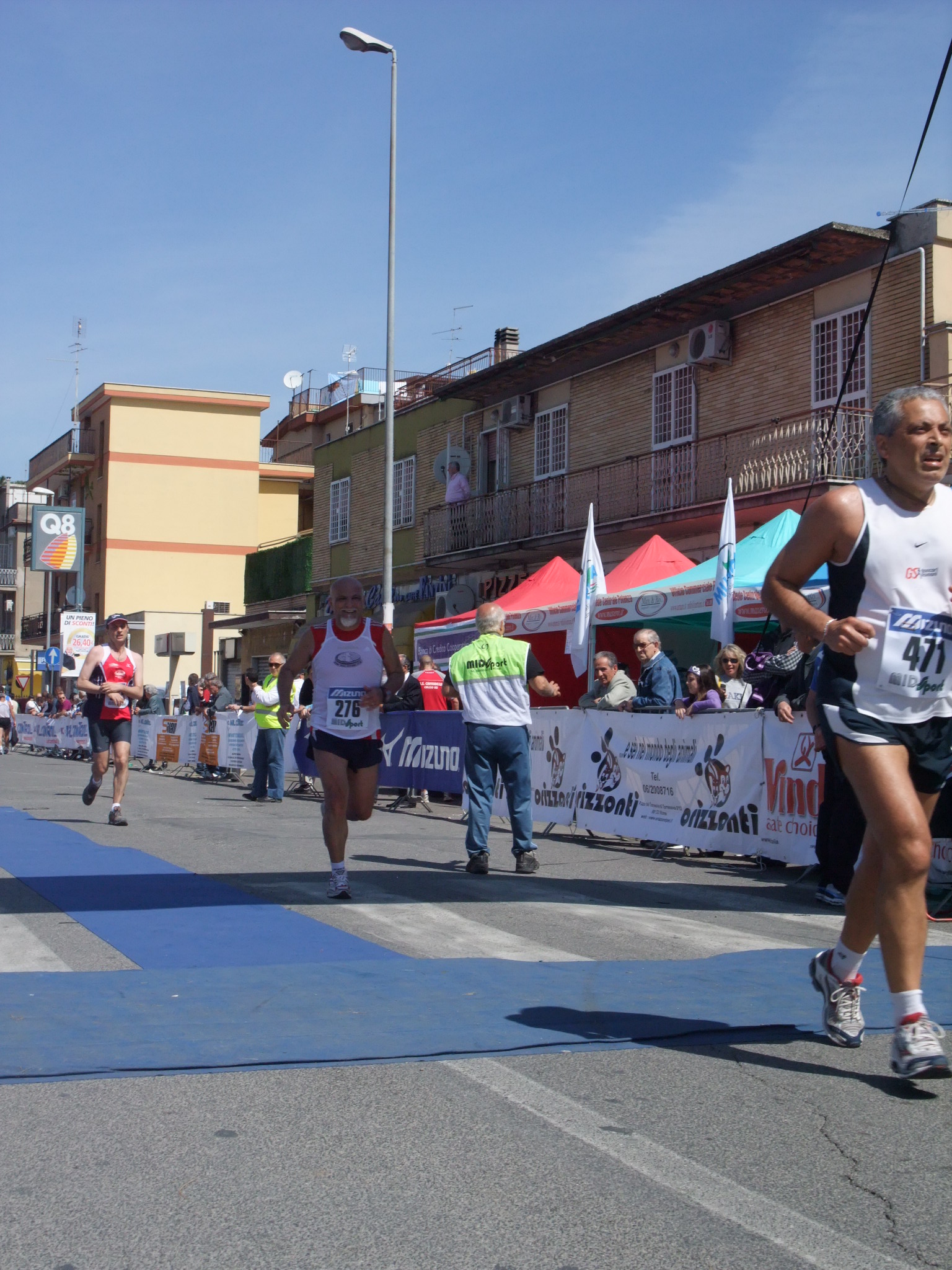 runners in running event on city street near crowd