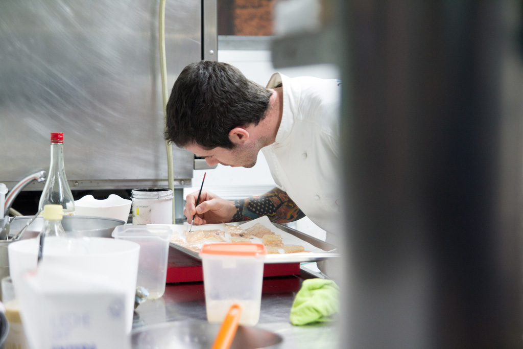 a chef writing in a notebook at a counter