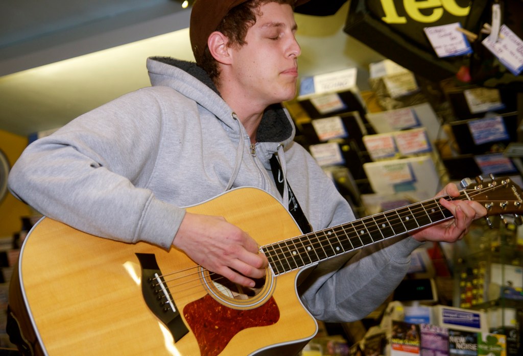 a man playing the guitar in a store