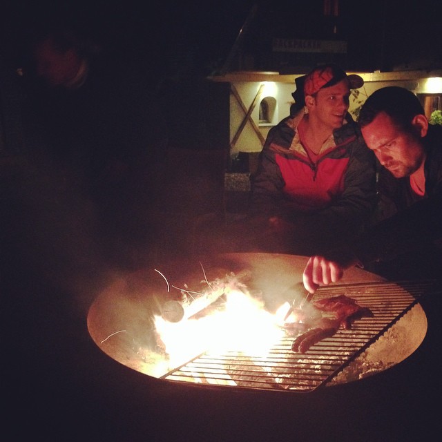 a man in black jacket grilling soing on grill