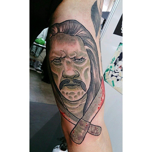 a man wearing a face and knife on his forearm