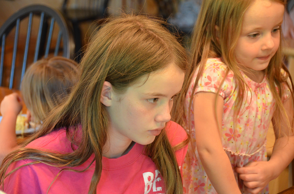 the two girls are standing beside each other eating