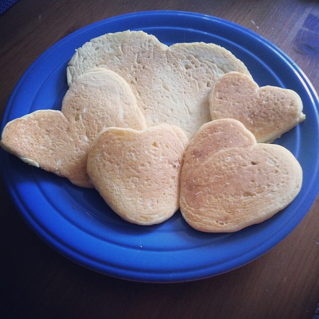 four heart shaped pancakes are sitting on a blue plate