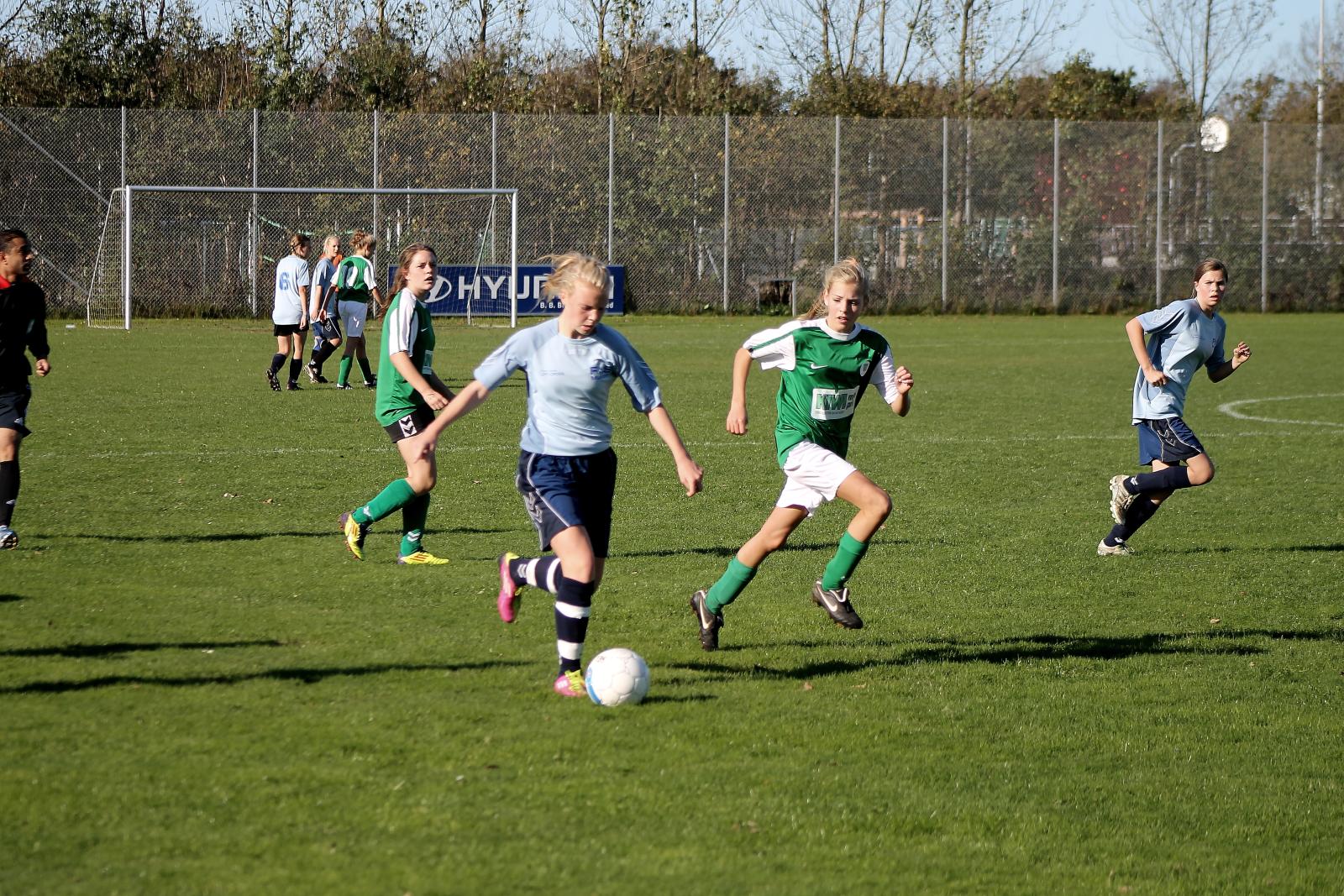 a group of girls are playing soccer on the field