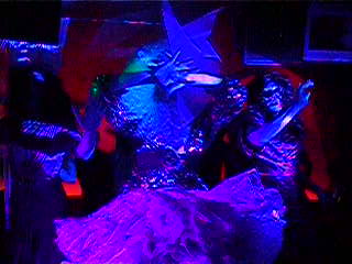 people in costumes on stage with blue and red lights