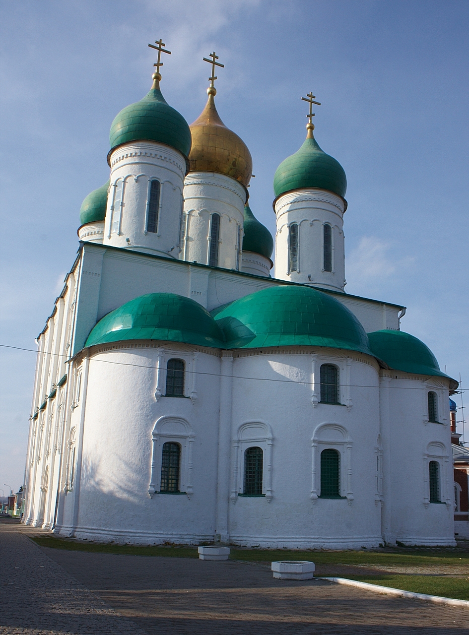 a white building with green domes and crosses on top