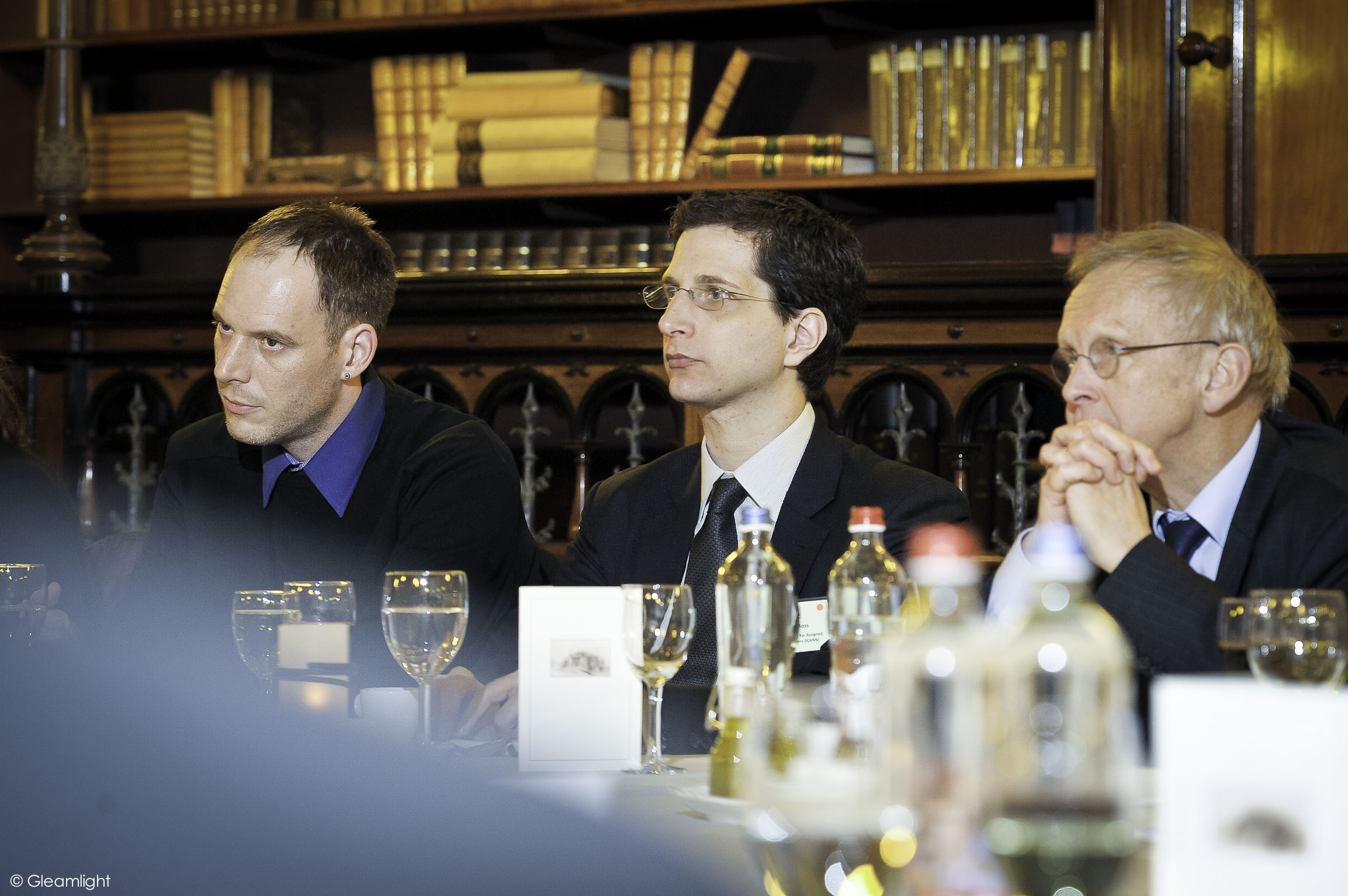 people sitting around a dinner table with wine glasses