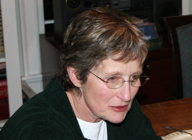 a woman with short hair in glasses looking at a phone