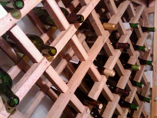many bottles of wine on a large wooden display