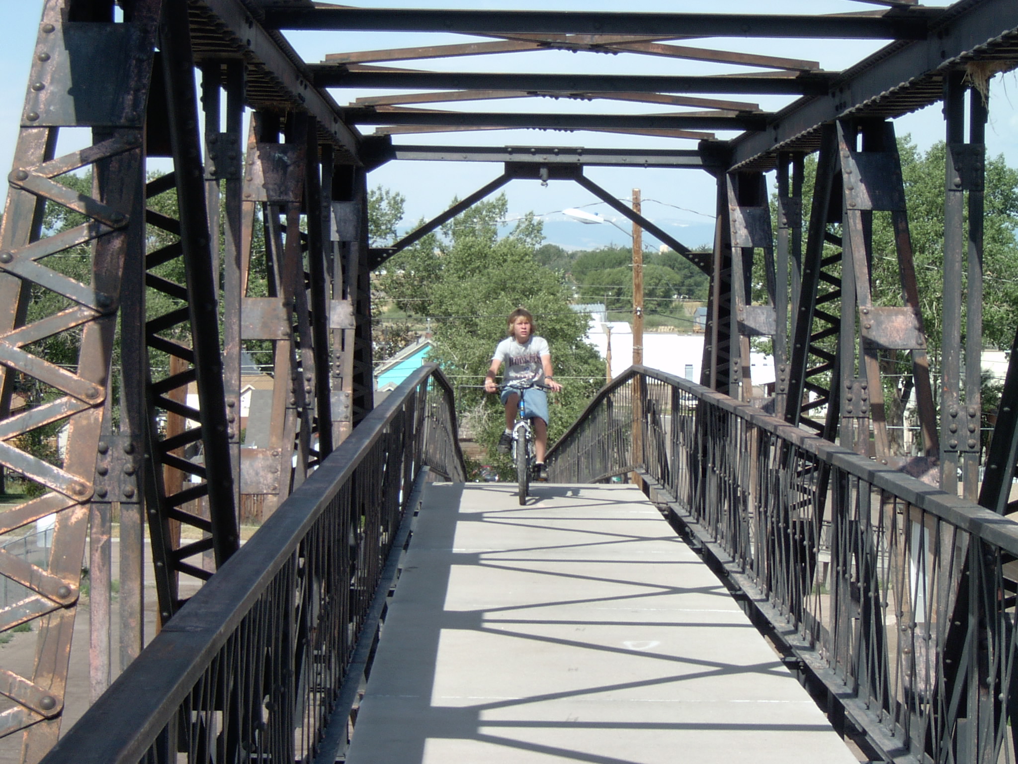 a man riding a bicycle across a bridge