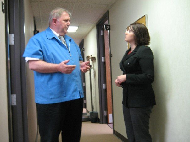 a couple of people in suits standing in an office hallway