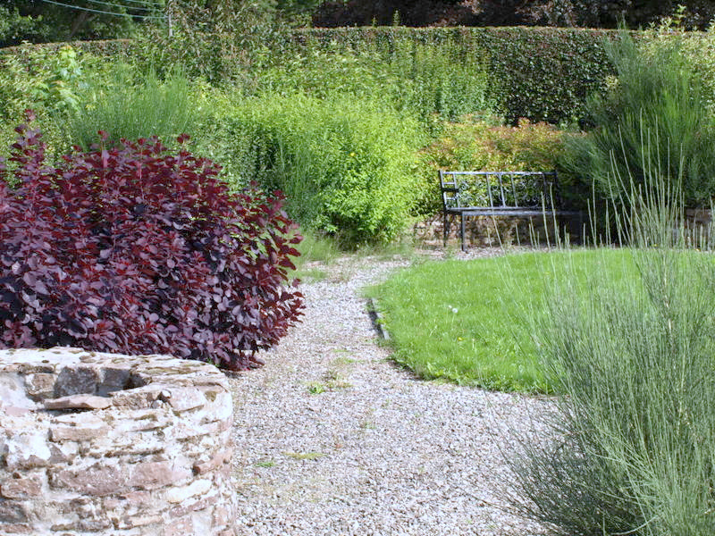 a garden area with a stone planter and plants