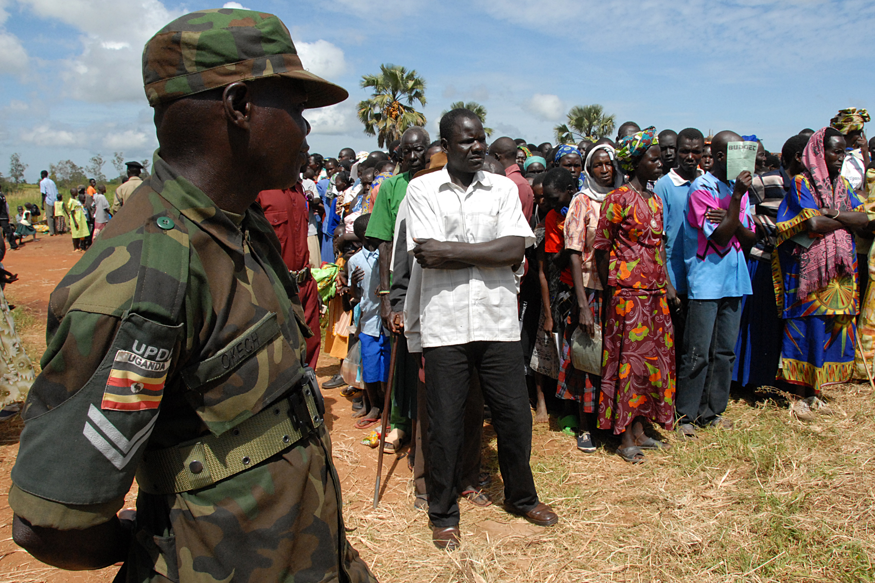 a man in camouflage standing near soldiers