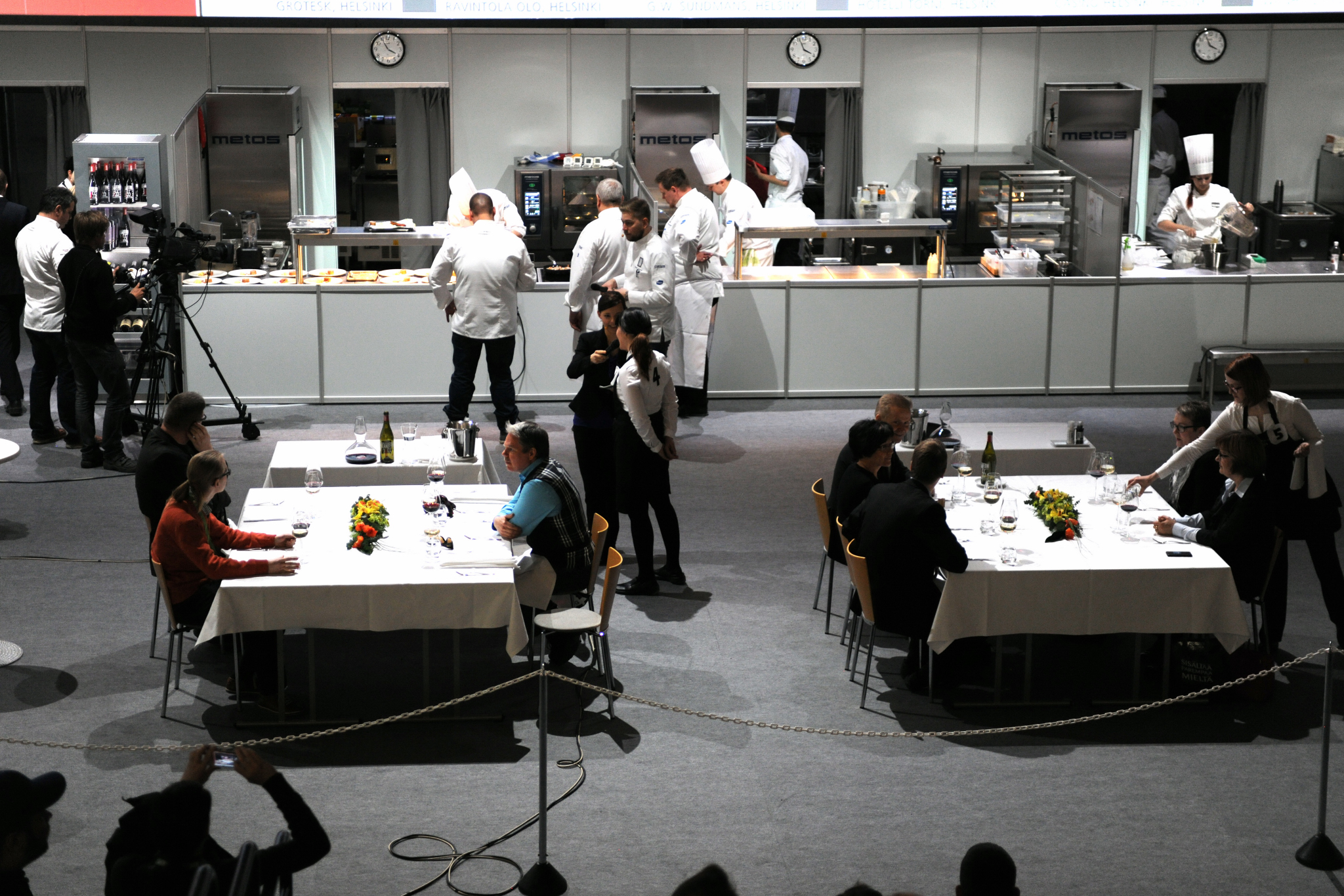 people wearing white chefs hats are gathered around tables