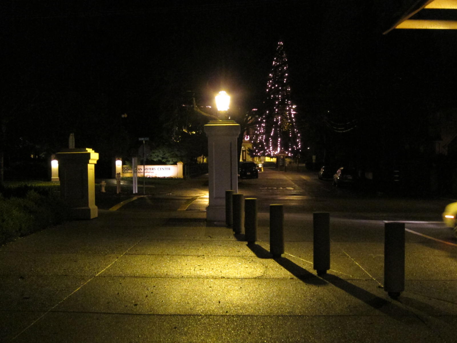 a street that has a fence by it at night