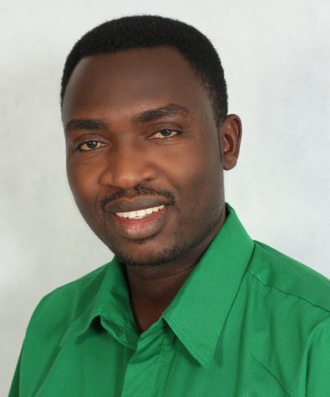 a man in a green shirt looking at the camera