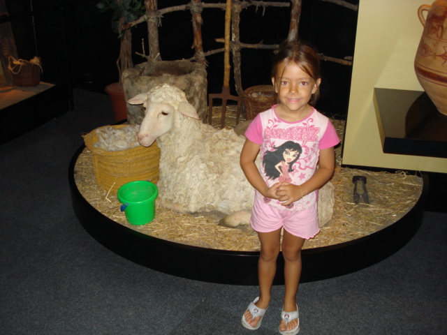 the girl in pink is standing next to a fake lamb